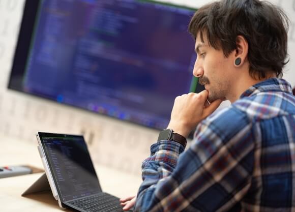 Student working on his laptop in a classroom