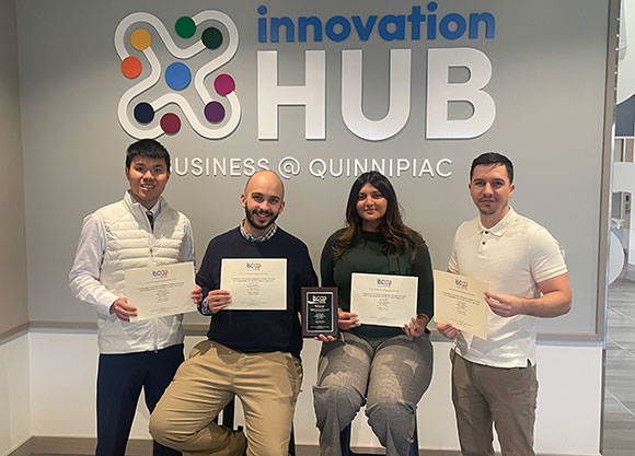 Quinnipiac students and faculty smile with awards