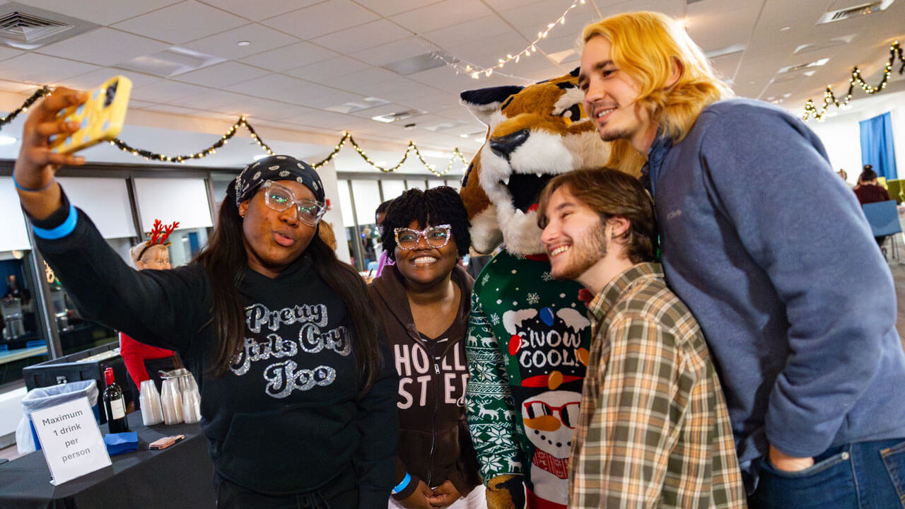 Students pose for a selfie with boomer